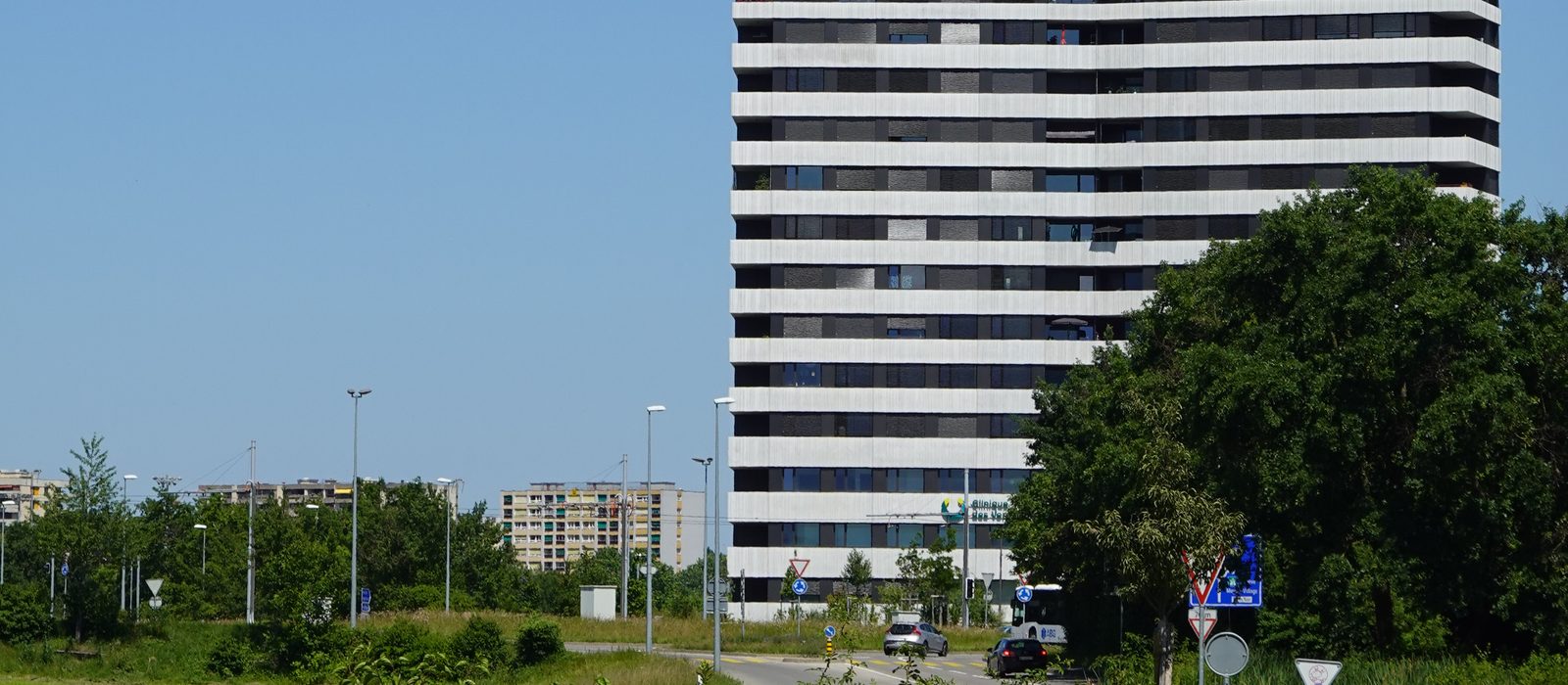 Rue et rond-point devant un immeuble de l'écoquartier des Vergers à Meyrin