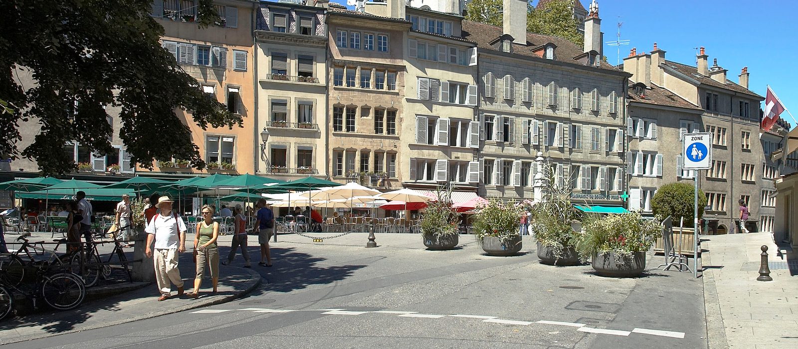 La Place du Bourg-de-Four animée, avec la Cathédrale Saint-Pierre en arrière-plan